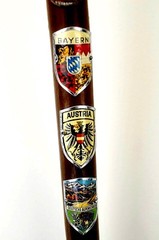 WOOD CANE WITH ELEVEN (11 ) HAND PAINTED ENAMEL METAL BADGE’S (GERMANY )