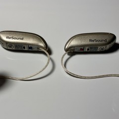 Left and Right Resound GN Hearing Aids and charging station w/cord.